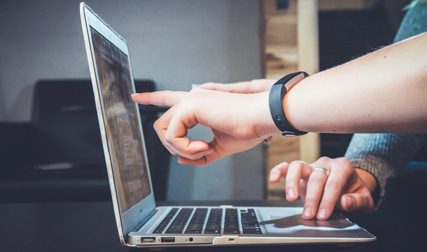 two people using laptop and pointing at screen