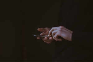 silhouette photo of person holding smartphone