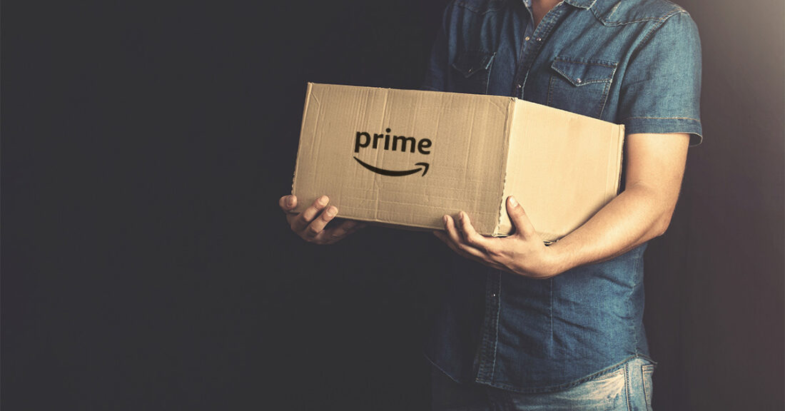 man holding a large cardboard box with Amazon written on it