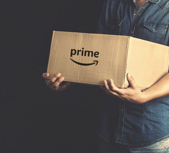 man holding a large cardboard box with Amazon written on it