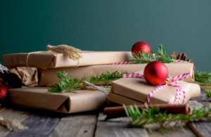 brown wrapped gifts with pine needles and red ornaments