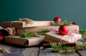 brown wrapped gifts with pine needles and red ornaments