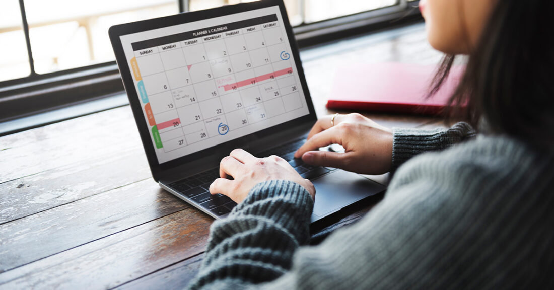 a woman looking at a calendar on a laptop