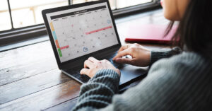 a woman looking at a calendar on a laptop