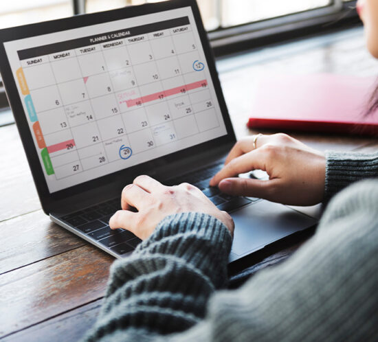 a woman looking at a calendar on a laptop